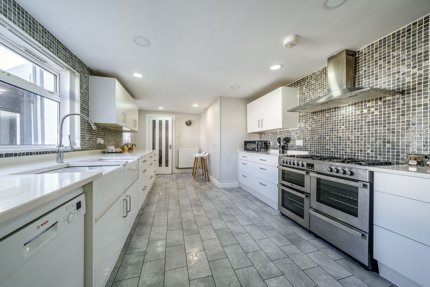 Long white kitchen with a range cooker and dishwasher, in Musselburgh