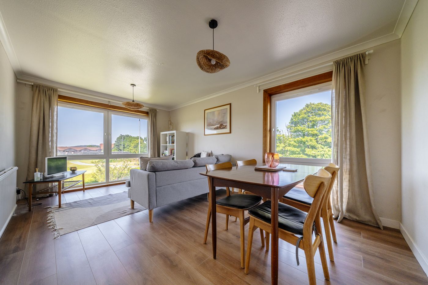 Bright living and dining room with big windows over the playing fields in a home we look after in Morningside